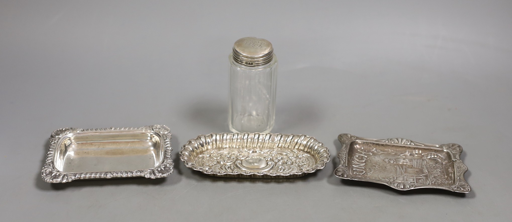 A late Victorian repousse silver 'Mr Punch' pin dish, Saunders & Shepherd, Birmingham, 1894, 10.7cm, one other silver dish, a silver mounted toilet jar and a plated small dish.